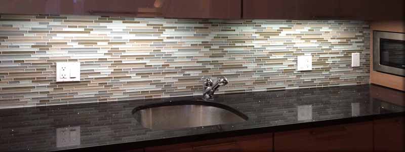 Stone countertop and glass backsplash kitchen